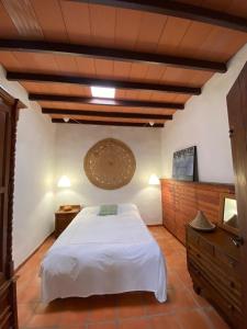 GüimeLa Cuesta14的卧室设有白色的床和木制天花板。