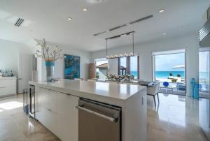 爱丽丝镇The Bahamas Beachfront Dream Villa的一个带大岛的厨房,享有海景