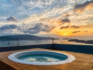 芽庄Venity Villa Nha Trang的甲板上的热水浴池,享有日落美景