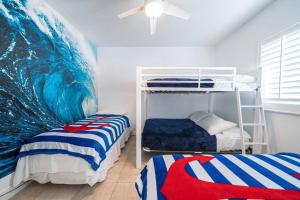 爱丽丝镇Bimini Blue Villa Villa的一间卧室设有两张双层床和波浪壁画