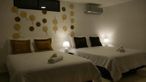 曼塔Park View Hostel & Suites的一间卧室设有两张床,墙上有两盏灯。