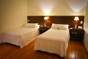 卡塔马卡Hotel Casino Catamarca的酒店客房设有两张床和两盏灯。