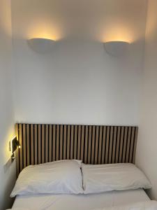 伦敦展苑4号酒店的床上有2个白色枕头,上面有2盏灯