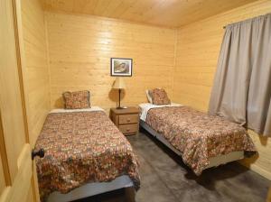 Heber SpringsLittle Red Riverfront Cabin的一间卧室配有两张床和一盏灯。