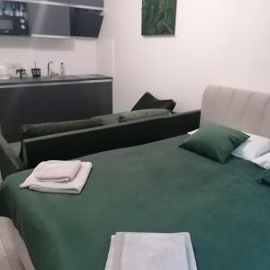 喀尔巴阡КарпатиКайзервальд.的一张绿色的床,里面装有毛巾