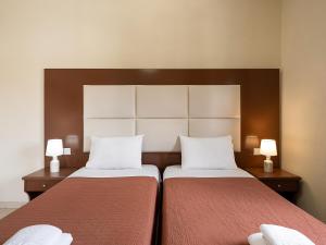 卡拉马基索非亚公寓酒店的配有2盏灯的酒店客房的2张床