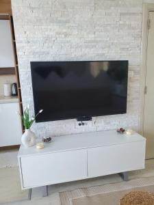 贝西奇Apartman Marija的砖墙上的白色娱乐中心,配有平面电视