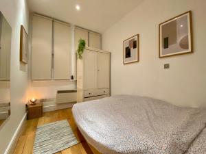 伦敦One-bed flat Central London Payment required STRAIGHT away The host will message you after you've made a reservation的一间卧室配有床和白色橱柜