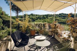 Arquata ScriviaVilla Paradiso Charme&Design的露台配有桌椅和遮阳伞