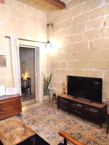 维多利亚Charming House in Victoria, Gozo的一间带电视和砖墙的客厅
