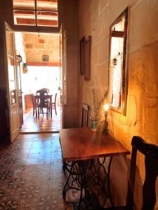 维多利亚Charming House in Victoria, Gozo的一间带木桌的房间和一间用餐室