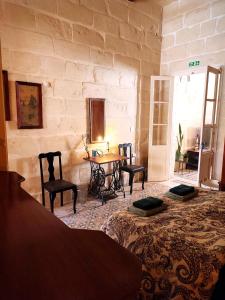 维多利亚Charming House in Victoria, Gozo的配有桌椅和石墙的房间