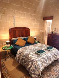 维多利亚Charming House in Victoria, Gozo的一间卧室配有一张床,上面放着两个托盘