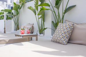 卡尼奥提Ampelia Hotel Kassandra的一张带枕头的沙发和一张植物桌子