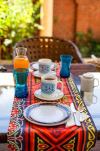 卢克索Dar Lina Guesthouse Luxor的桌子,盘子,咖啡杯和果汁