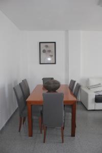 马拉加Apartamento en Ciudad Jardin的餐桌,椅子和碗
