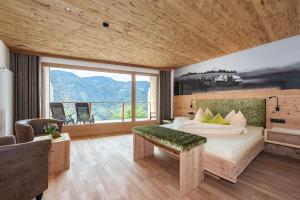 卡斯特尔罗托Luxury and Nature House Moarlhof的一间卧室设有一张床和一个大窗户
