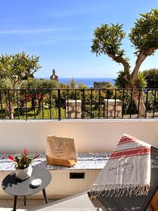 卡普里Le donne di Capri - Charming apartments in Capri的阳台配有桌子,享有海景。