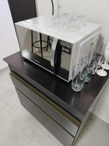 伊帕廷加Executivo Veneza的微波炉,放在带眼镜的柜台上
