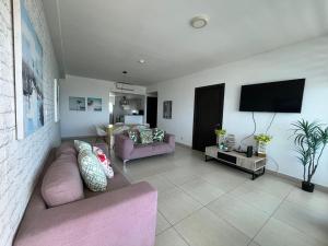 普拉亚布兰卡Playa Blanca Beach Rentals的客厅配有粉红色的沙发和平面电视。