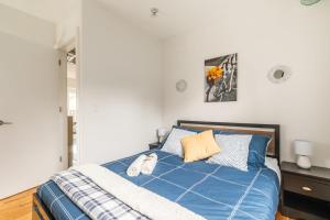 多伦多Modern 2 BR Condo - Heart of Leslieville的一间卧室配有蓝色的床和两个枕头