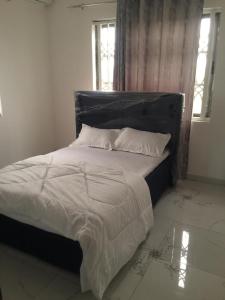 AfienyaSerengeti Rest Lodge的卧室内的一张带白色床单和枕头的床