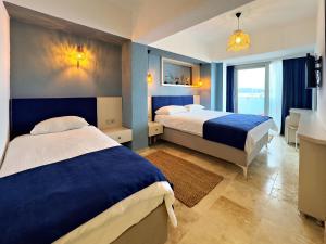 博德鲁姆纳斯住宿加早餐旅馆的酒店客房,设有两张带蓝色墙壁的床