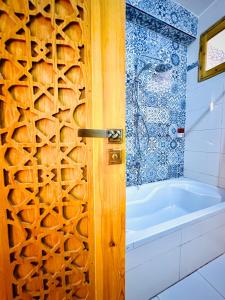 卢克索Dar Lina Guesthouse Luxor的一间带木门和浴缸的浴室