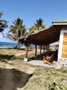 大玉米岛La Princesa de La Isla的海滩上的小屋,配有椅子和海洋