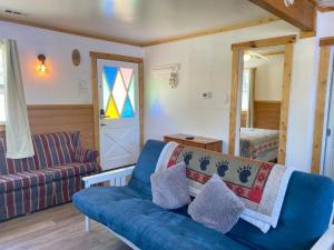 大熊湖Blue Horizon Lodge的客厅设有蓝色的沙发和窗户。