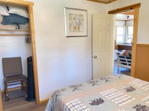 大熊湖Blue Horizon Lodge的一间卧室,卧室内配有一张床和一把椅子