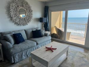 新士麦那海滩Ponce de Leon Towers的客厅配有沙发和咖啡桌上的海星