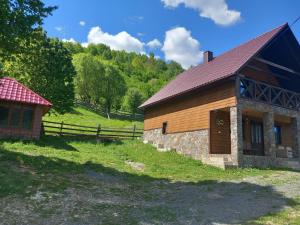 库尼贡达Синевирський Краєвид的一座带围栏的木结构建筑,毗邻田野