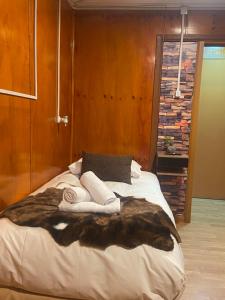安库德Hostal Queltehue的一间卧室配有一张大床和一张仿毛皮毯子