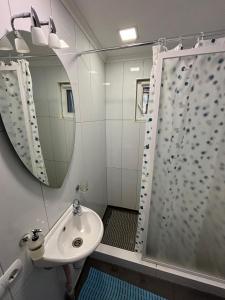 尤尔马拉River bank vacation home的浴室配有盥洗盆和带镜子的淋浴
