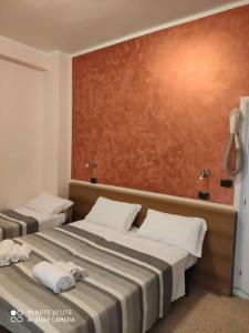里米尼Hotel Prestige 3 Stars的两张位于酒店客房的床,配有毛巾