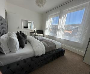 伯恩茅斯5 min from the beach En suite room in Guest house的一间卧室设有一张大床和两个窗户。