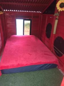 圣玛尔塔El Parque del Loro的红色木制客房内的一张红色大床