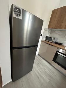 斯基罗斯岛Filia Skyros Suites的厨房里的一个不锈钢冰箱,旁边是微波炉