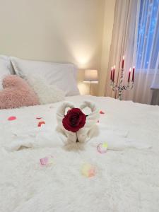 埃格尔Albina apartman的一张白色的床,上面有玫瑰和一种填充动物