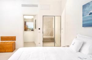 卡普里Le donne di Capri - Charming apartments in Capri的白色卧室设有一张床和一个步入式淋浴间