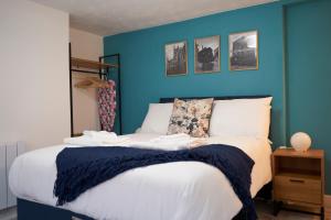 Garden Apartment by Kahuna Stays的一间卧室设有蓝色的墙壁和一张床