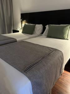 布宜诺斯艾利斯Duomi Hotel Buenos Aires的两张睡床彼此相邻,位于一个房间里