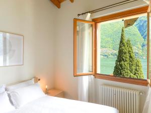 拉利奥Villa Luminosa Laglio - Private Parking, Garden的卧室配有白色的床和窗户。