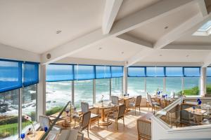 伍拉科姆霍特密斯酒店的一间配备有桌椅的海景餐厅