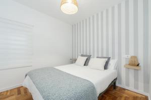 奥波里尼奥Ohana Home的白色卧室配有一张床和吊灯