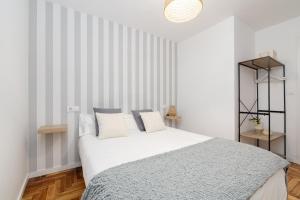 奥波里尼奥Ohana Home的卧室配有一张白色大床和条纹墙