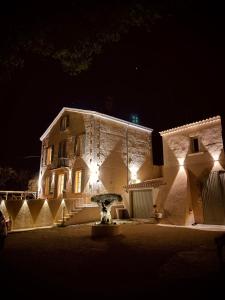 Puyvert#LUXE# Maison de maître provençale的一座在晚上有灯的大建筑