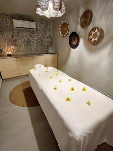 圣胡安Bali Poshtel PR的一张白色的大床,上面有黄色的花朵