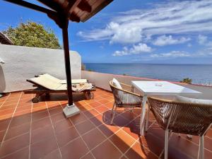 阿古洛Villa Delfines的一个带桌椅的庭院和大海